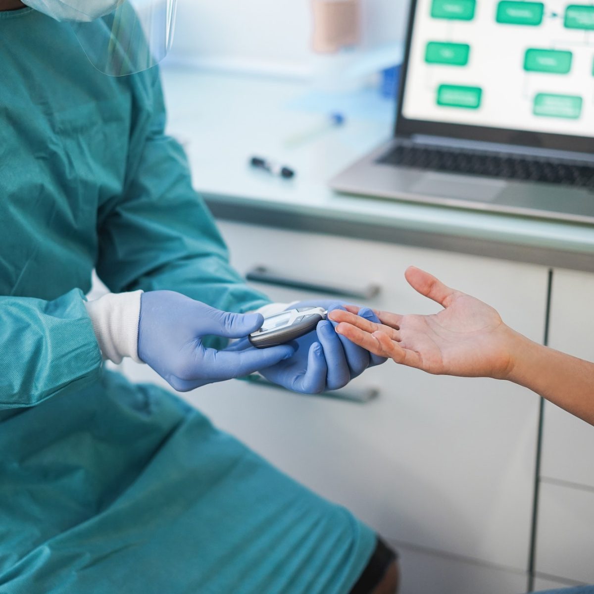 Doctor making blood glycemia test to young woman in medical clinic for diabetes