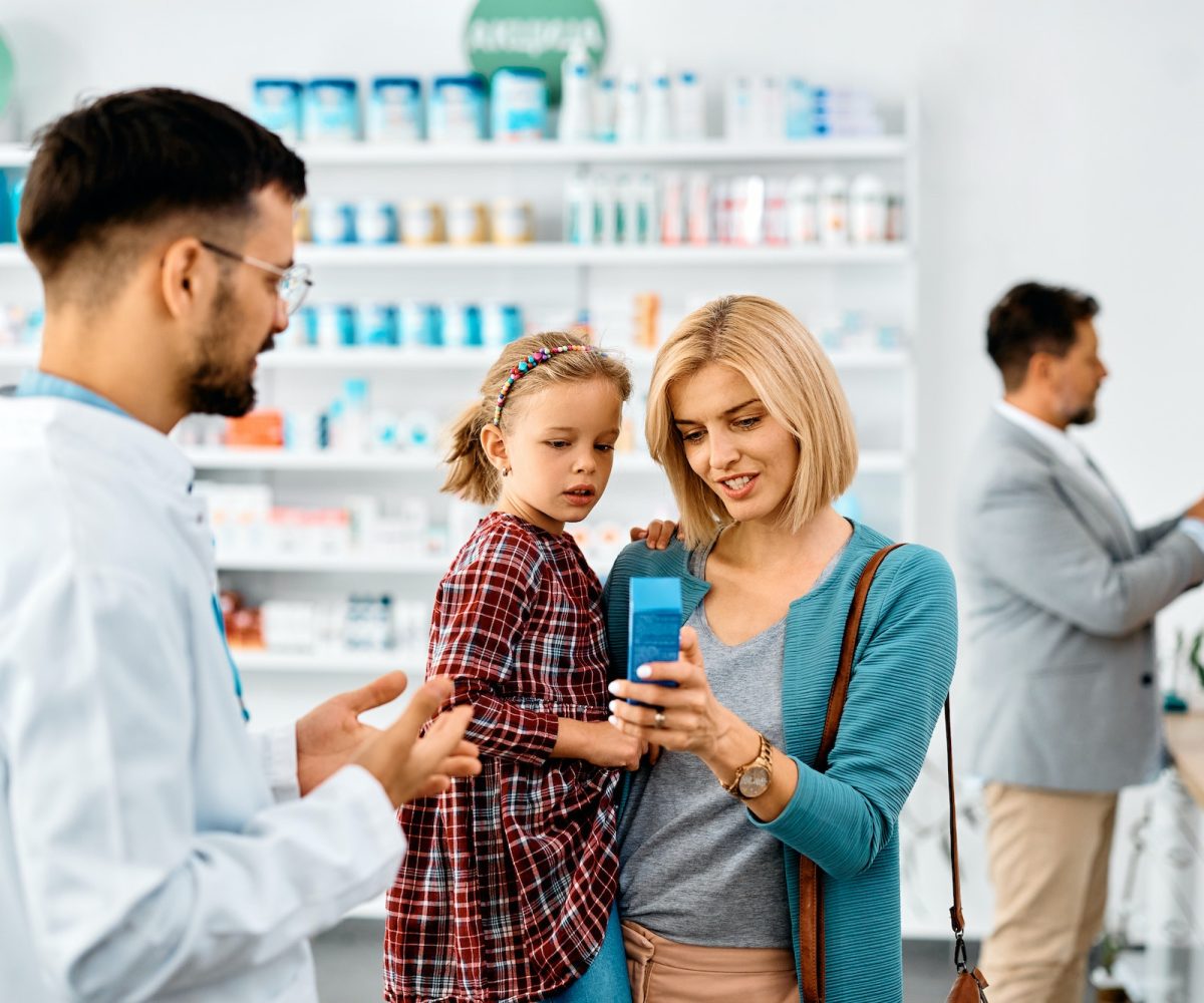 Happy mother with daughter buying in a pharmacy,