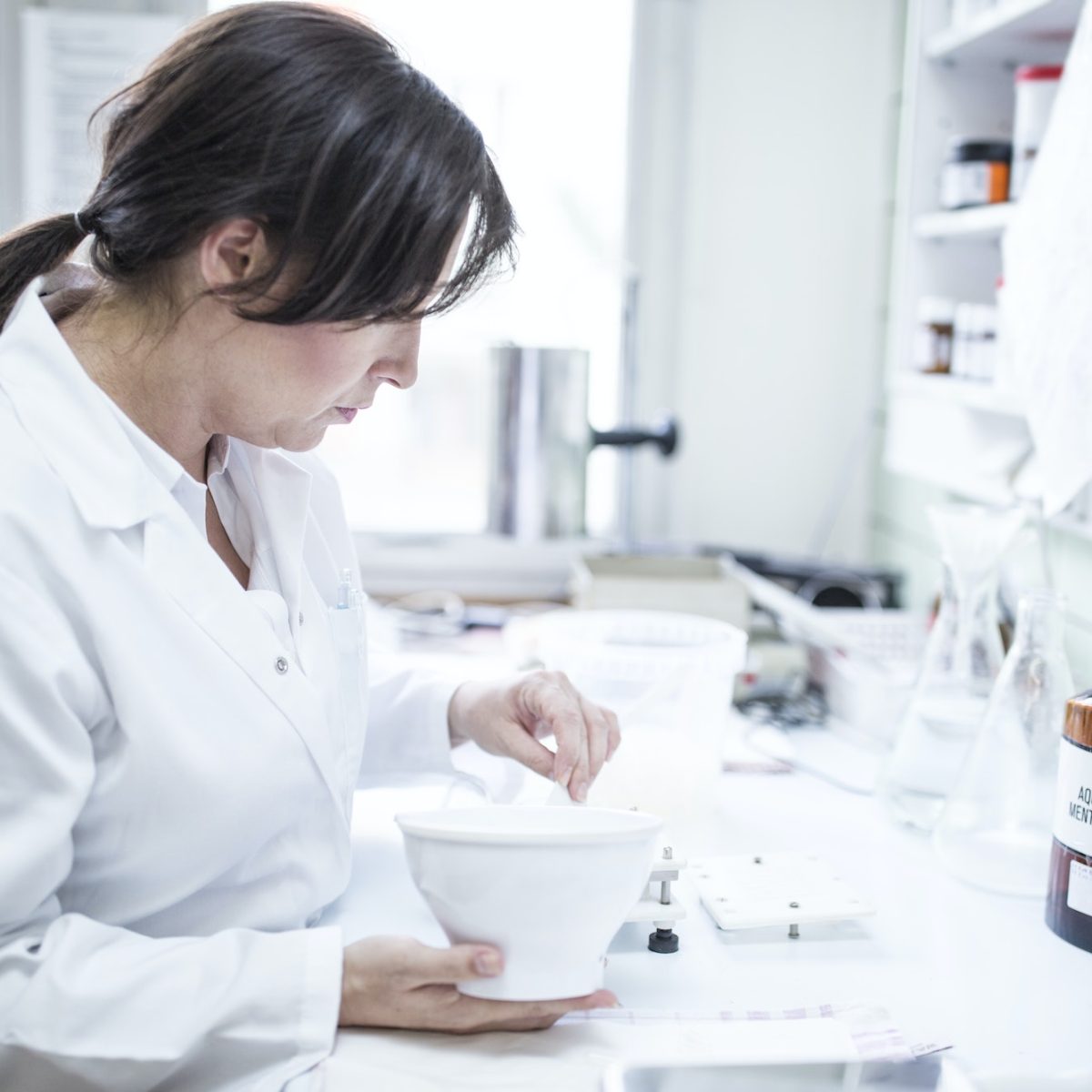 Woman preparing medicine in laboratory of a pharmacy